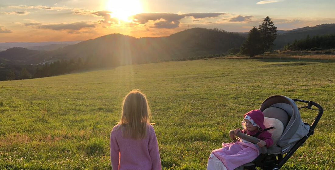 Nadines Familie von hinten beim Spazieren gehen im Sonnenuntergang zeigt: Nadine arbeitet nahbar mit dir und kennt deine Situation und deine Lebensentwicklung aus eigener Erfahrung sehr gut.